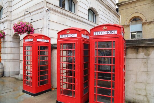 London red telephone in rainy weather. English symbol - red phone booths street view in the City of Westminster.