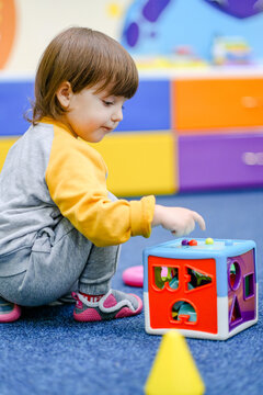 Early baby development. Little boy plays in the children's room. A child plays at an early childhood development center.