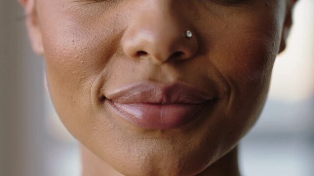 Starting speech, woman showing front teeth then shifting into gentle smile near window