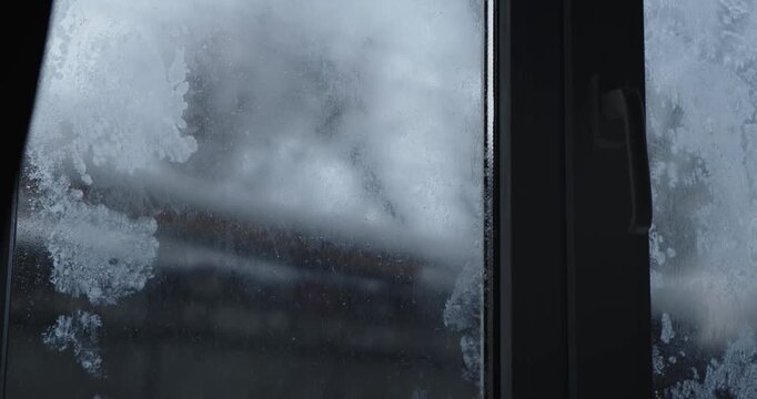 Close up of frost patterns on window glass, capturing the cold essence of winter. The process of frost patterns forming, time lapse video.