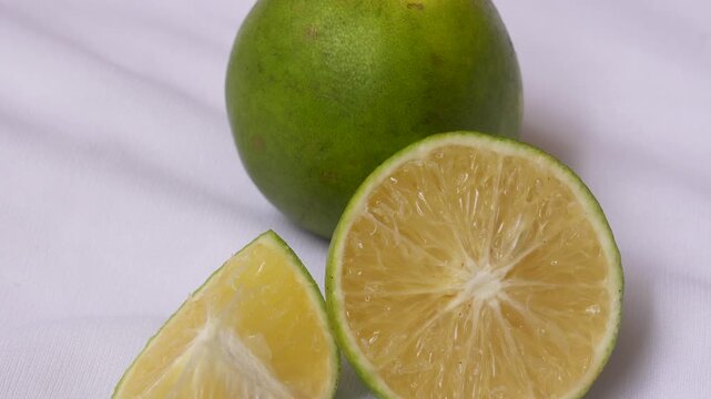 Organic Indian Citrus fruit sweet limetta or mosambi with its sliced part on white background. It is a cross between the citron and a bitter orange. Scientific name Citrus limetta