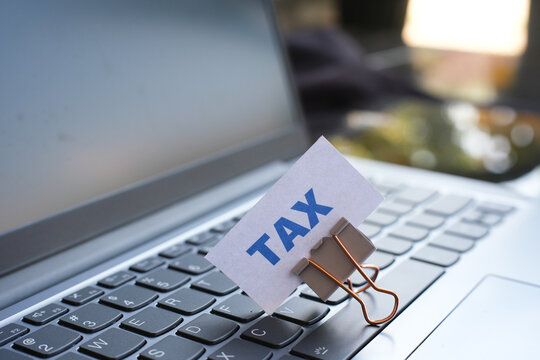 "TAX" text above the keyboard. Tax payment reminder concept.