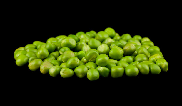 Green peas isolated on a black background.