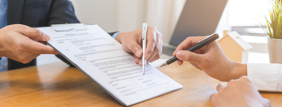 Asian landlord, realtor man pointing on paper for sign signature contract with tenant rental or client, realtor purchase, buyer home or apartment, agreement mortgage, property lease agent concept.