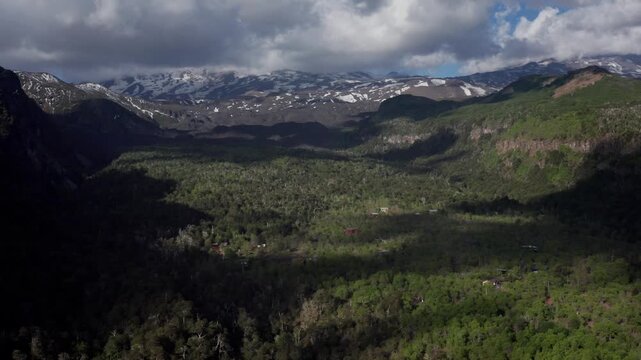 Aerial view of forested mountains and rural valley landscape