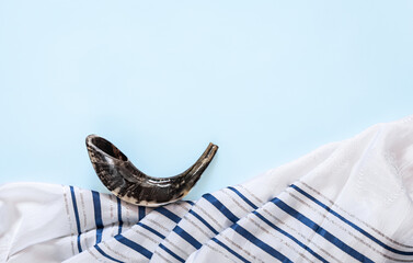 Fototapeta na wymiar Shofar across tallit, Yom Kippur greeting concept. Jewish holiday banner with tallit and shofar