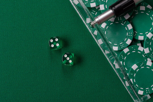 Dice and chips on a green felt gaming table, a poker game in a casino. Casino dice