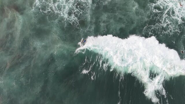 Aerial View of Surfers Riding Powerful Ocean Waves From Above