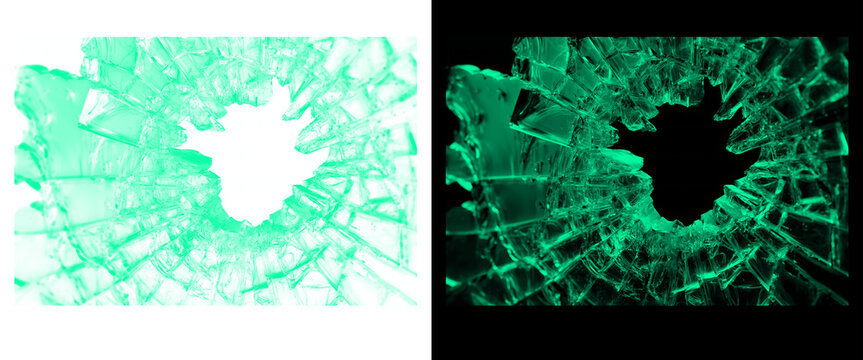Shattered glass hole with green glowing light, broken window shards on black and white background, cracked glass texture for crime or accident concepts