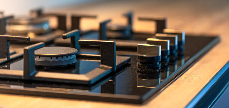 Gas cooktop burner and control knobs. Close view of modern kitchen equipment.