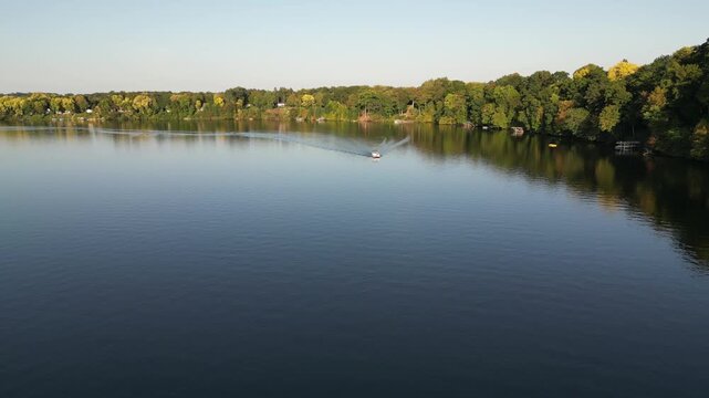 Aerial over Lake Chapin, a dammed lake along the St. Joseph's River. Near Berrien Springs, in Berrien County, within Oronoko Charter Township, Michigan, United States. Passing a pontoon boat.