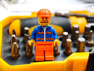 Fototapeta premium Russia, St. Petersburg, August 8, 2020 A lego man standing in front of a bunch of screws, great for DIY or construction theme