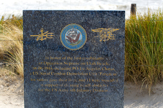 Close-up of stone table remembering Angelos Chatas US Navy frogman at memorial site at Utah Beach on a sunny summer day. Photo taken July 16th, 2026, Utah Beach, Normandie, France.