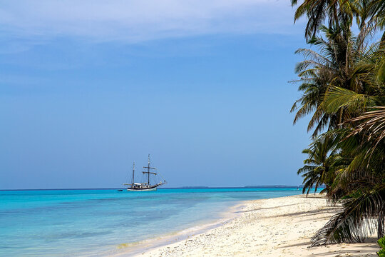 Maldives, Traditional boat on the ocean near a tropical beach.