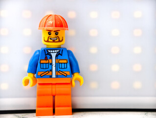 Fototapeta premium Russia, St. Petersburg, August 8, 2020 A close-up of a Lego man wearing a hard hat, great for illustration or construction-themed designs