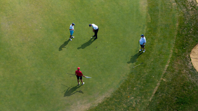vue a&eacute;rienne au dessus d'un green sur un terrain de golf, les joueurs son autour du dernier trou pour finir la partie; 