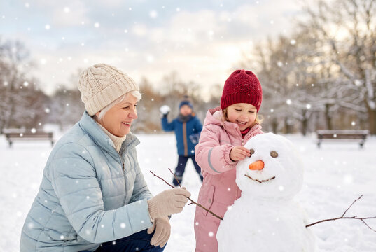 Abuela y nieta construyendo un mu&ntilde;eco de nieve durante una jornada de invierno