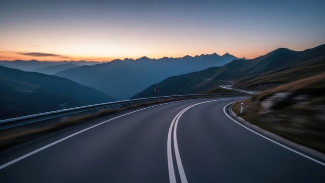 Winding mountain road at sunset with dramatic sky