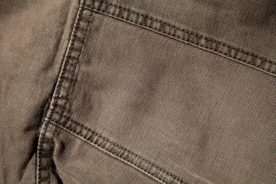 Close-up of distressed brown vintage fabric with frayed edges. Authentic rough textile showing natural aging, scratches and material texture.	
