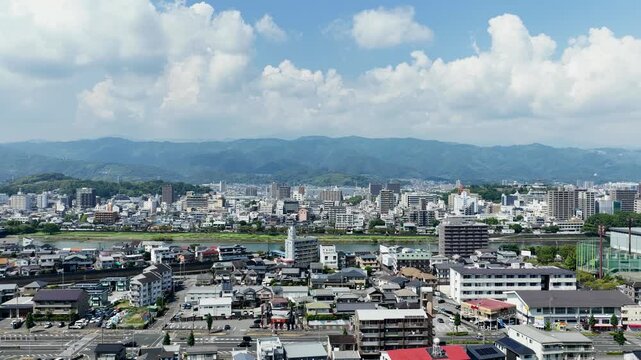 Aerial drone footage rising over Kochi city with river and mountains, Japan