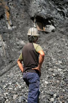 Mining worker standing inspecting coal mine site