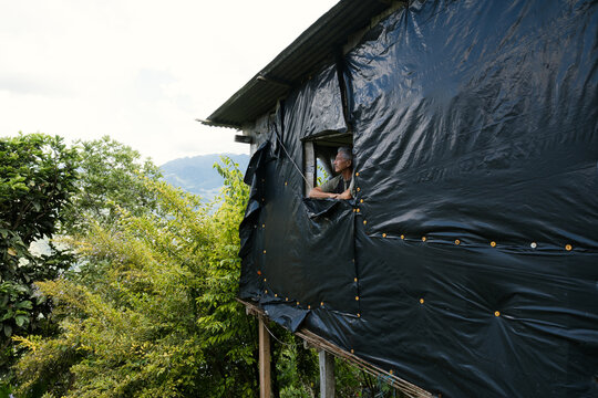 Man looking out window of makeshift house