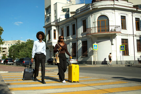 Two Black professionals with suitcases in business trip.