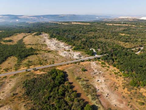 Aerial view of the Pobiti Kamani rock formations, also known as the Stone Forest, featuring natural stone pillars in a sandy landscape surrounded by forests in Slanchevo, Varna, Bulgaria.