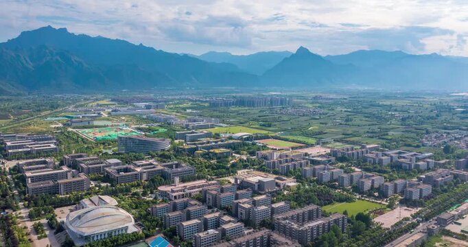 Aerial view of a university campus with sports fields and mountain range in the background