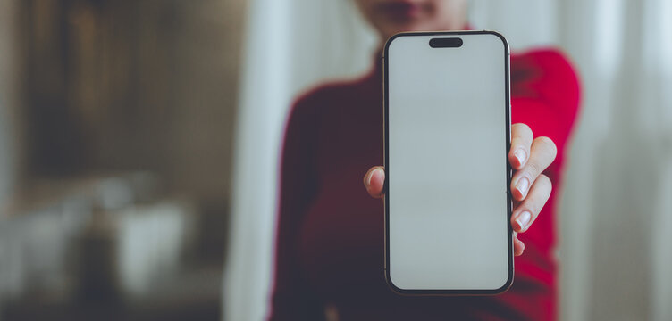 A person holding a blank smartphone and takeaway coffee, representing mobile communication, modern lifestyle, digital technology, and everyday convenience.
