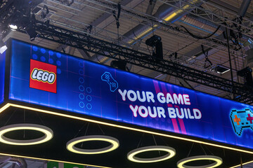 Fototapeta premium Cologne, Germany - August 26, 2026: LEGO booth display at gamescom featuring vibrant graphics and the slogan 