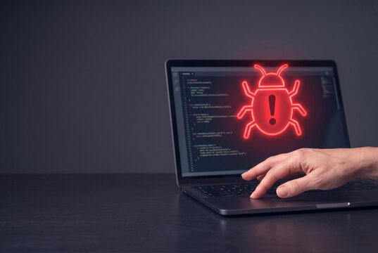 Hand pointing at laptop screen displaying coding bug alert  
