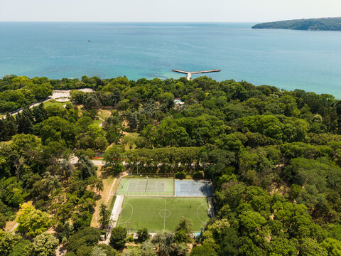 Aerial view of Seaside Park in Varna, featuring lush green trees, tennis courts, a soccer field, and a pier extending into the Black Sea, Varna, Varna, Bulgaria.