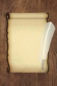 White feather quill pen and parchment paper scroll on rustic wood background. Blank grunge stationery for old fashioned love letter, invitation, diploma.
