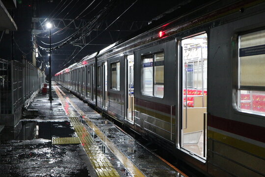 Jakarta KRL commuter line train at station platform at night
