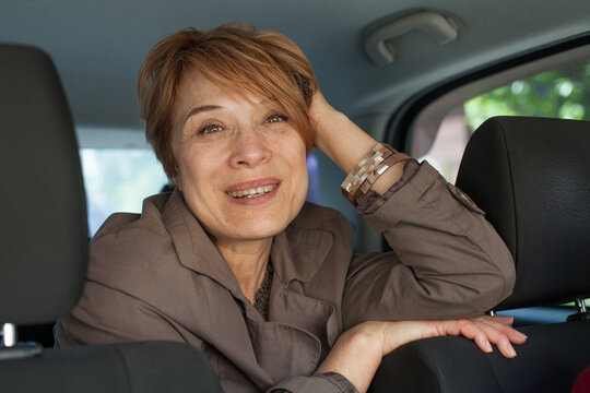 Joyful real woman passenger sitting in car, closeup portrait