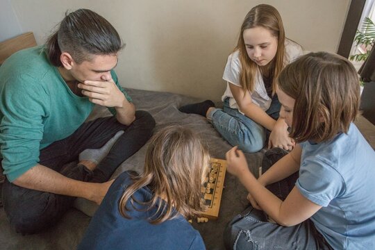Group of friends plays chess together indoors during a day of fun and friendly competition