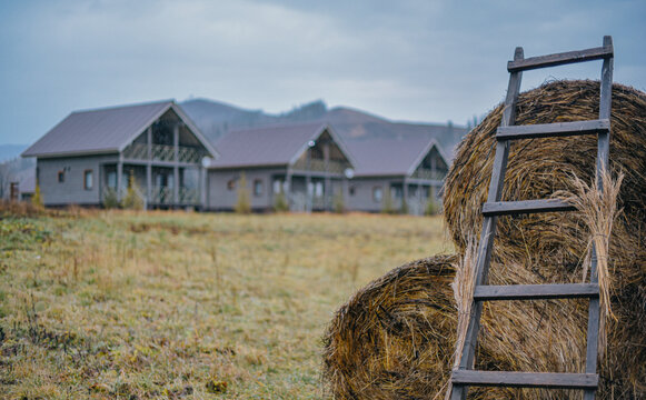 Wooden village houses and haystack against autumn hills in East Kazakhstan, autumn decor