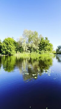 A peaceful summer day along the Sula River features lush greenery, calm waters and picturesque natural scenery in Poltava region, Ukraine
