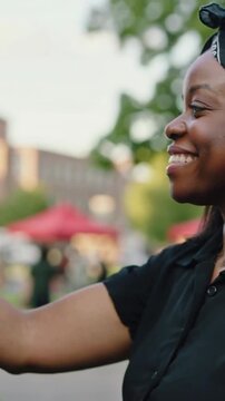 Vertical video: After cook handing plate woman in black taking dish to eat at park truck