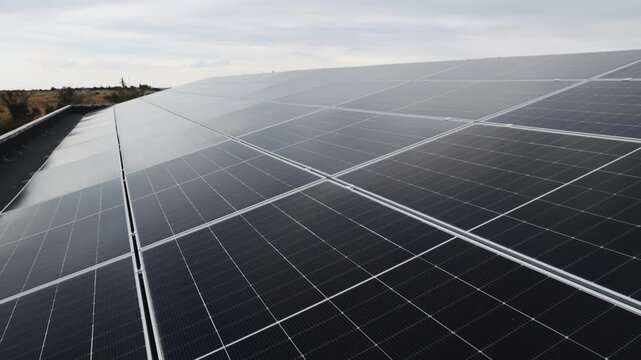 Solar panels form long geometric rows across a rooftop. Renewable energy, clean electricity and modern power generation concept.