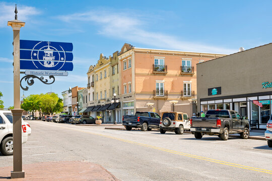 18th century Front Street, the main street of shops and cafes, with a historical marker pointing towards the waterfront Harborwalk, in Georgetown, South Carolina, August 12 2026.