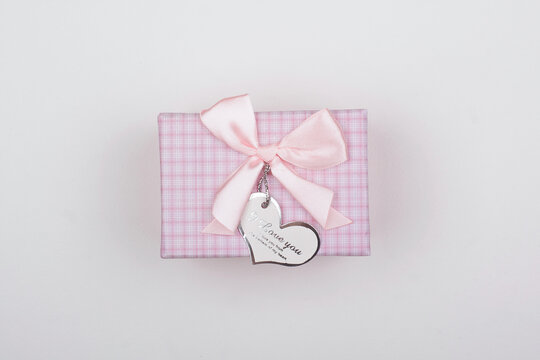 Pink gift with bow on a white background. Heart note I love You.