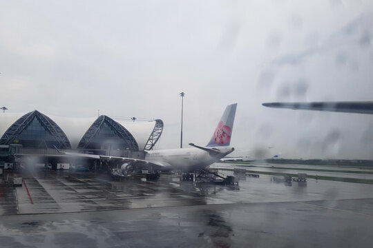 Bangkok, Thailand - April 07, 2018 - China Airlines Airbus A330 connected to jetway at Suvarnabhumi Airport Bangkok terminal on a rainy day