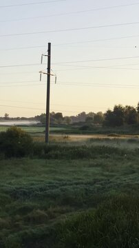 Sunrise emerges through mist over the Sula River creating a serene golden landscape with calm water and soft morning light in Poltava region, Ukraine
