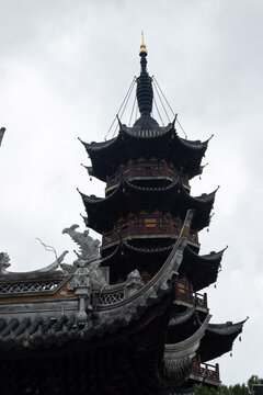 Close-up of ancient Chinese pagoda tiers, iron spire with gilded tip and ornate roof ridges, Suzhou, China