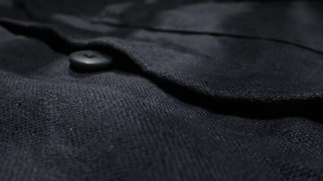 Close-up detail of a blue linen shirt showing natural fabric texture. Concept of eco-friendly clothing, natural materials and fashion.