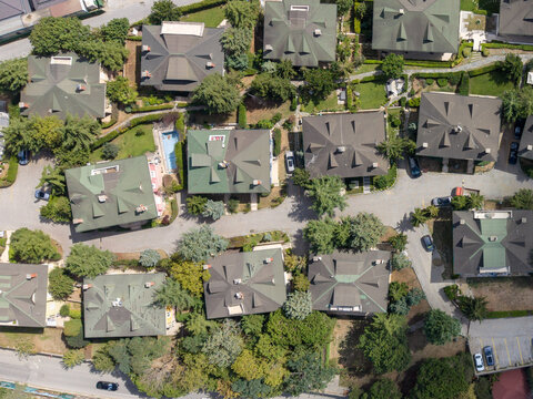 Aerial view of residential houses with green roofs surrounded by lush trees and winding roads in Istanbul, Istanbul, Turkiye.