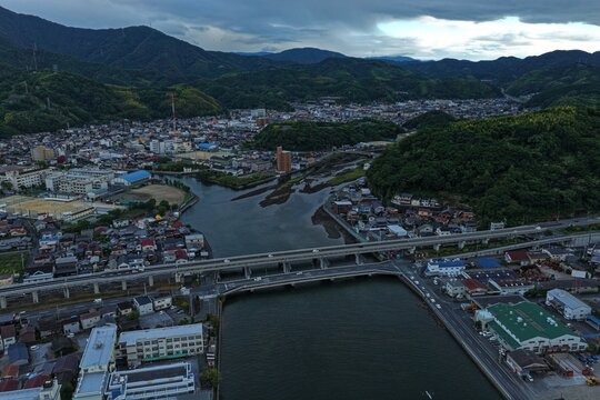 Aerial drone photo of urban cityscape with river and bridge in Uwajima, Ehime, Japan
