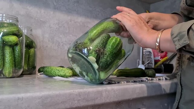 Pickling cucumbers in jars on a kitchen counter during a summer afternoon